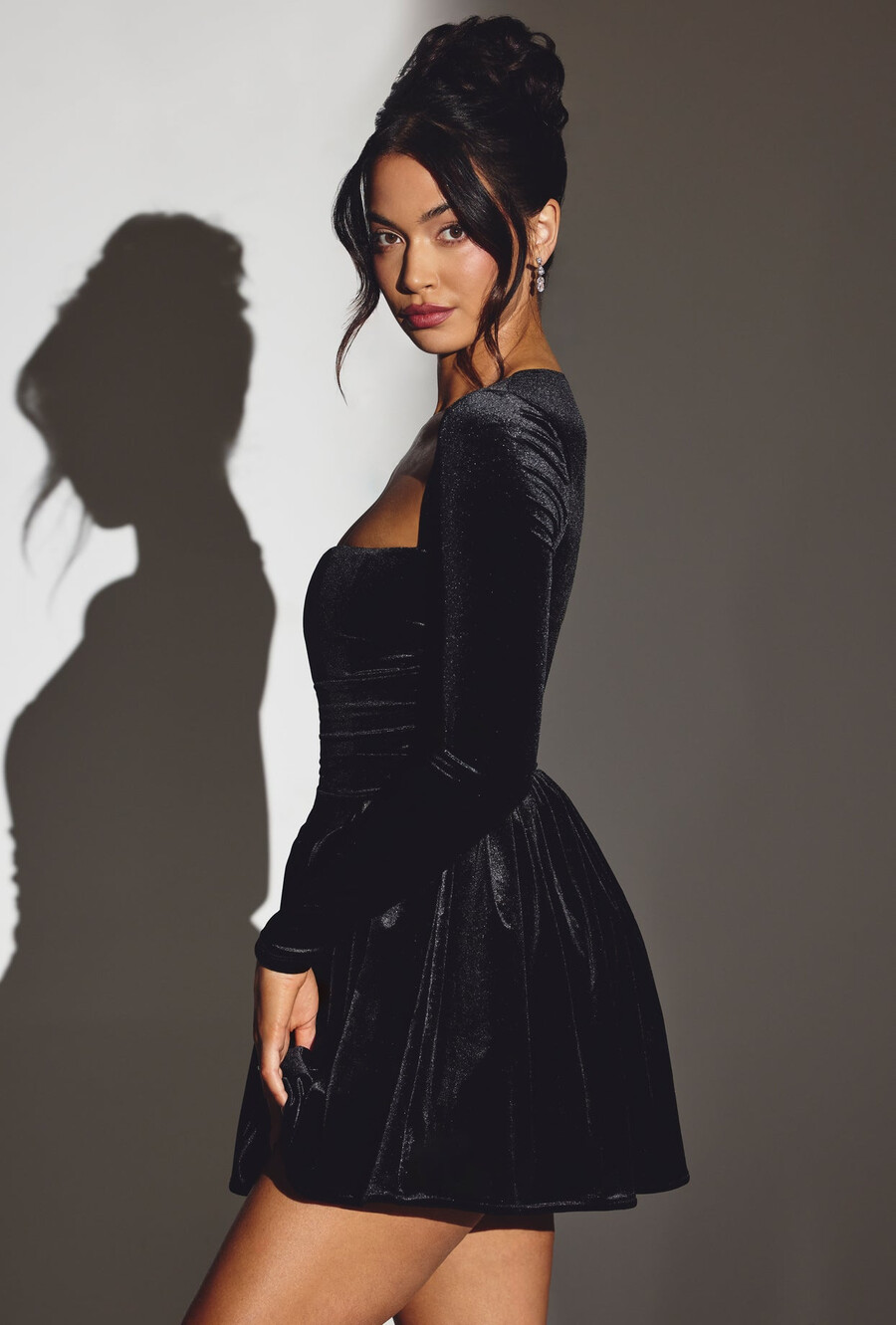 vestido curto de veludo preto com espartilho e mangas compridas.