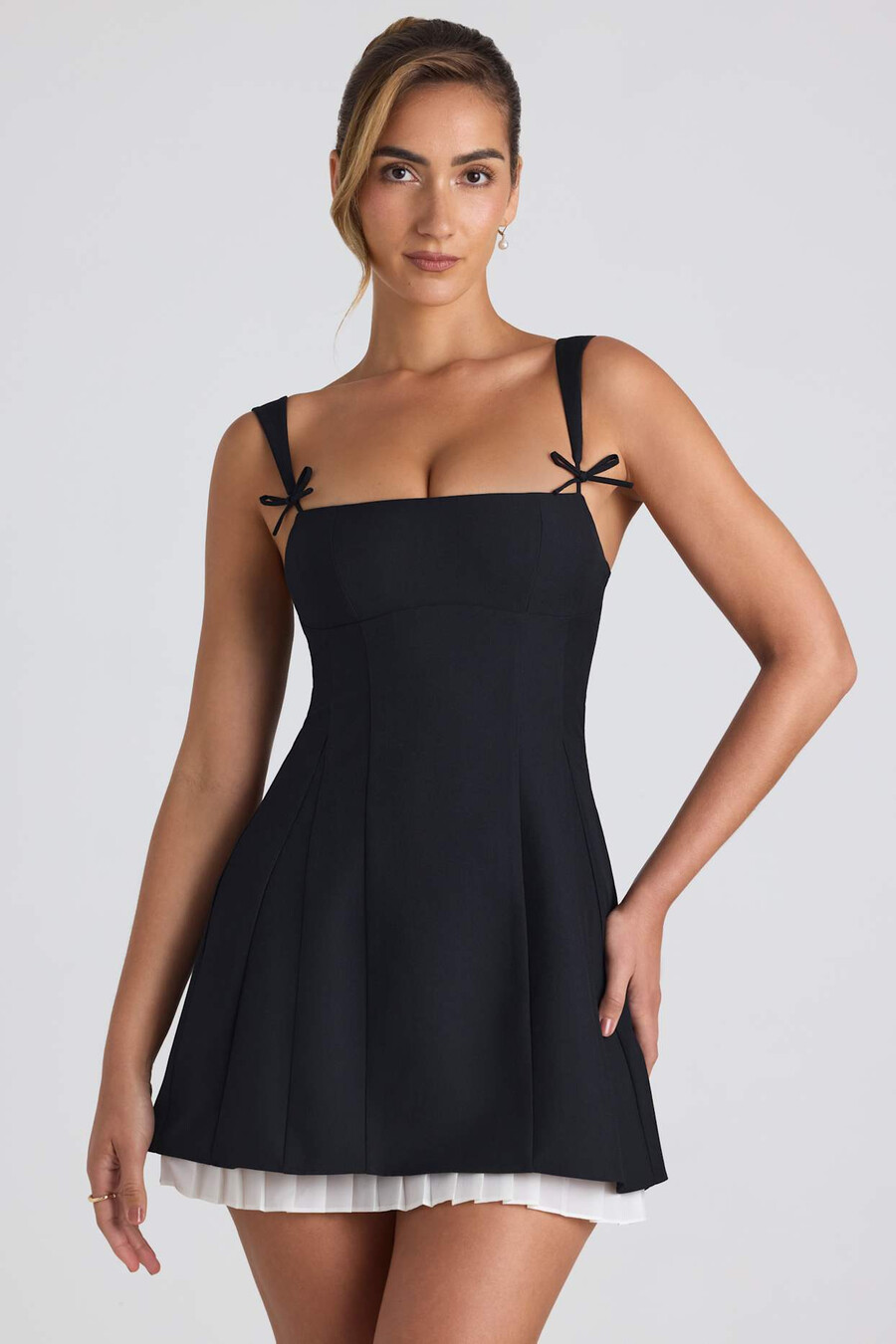 vestido curto evasê plissado com detalhe de laço na cor preta.