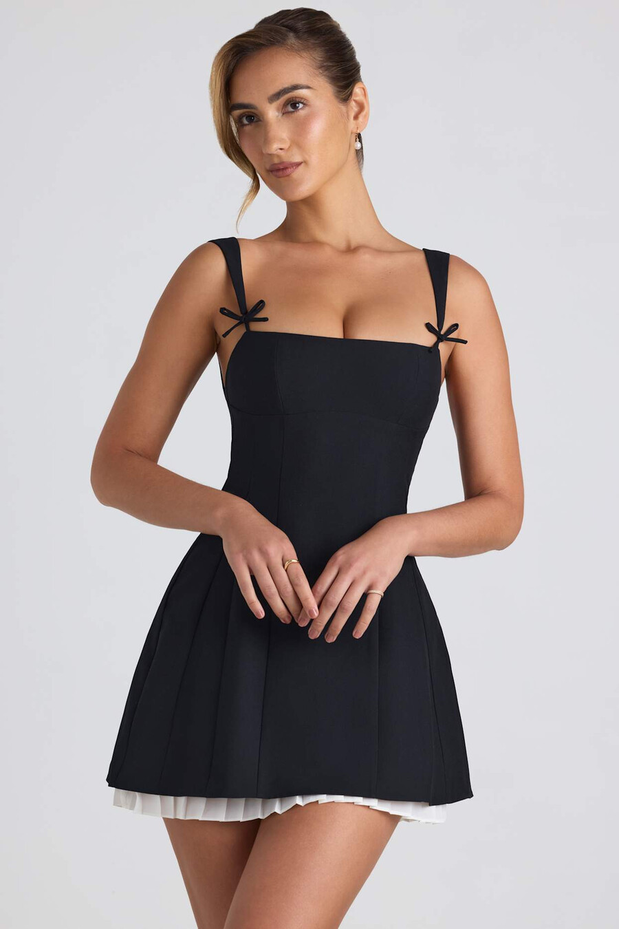 vestido curto evasê plissado com detalhe de laço na cor preta.
