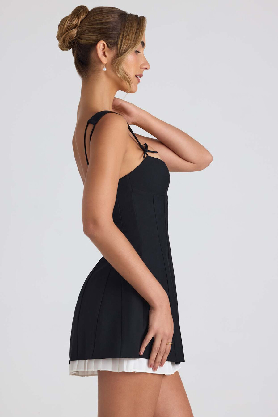 vestido curto evasê plissado com detalhe de laço na cor preta.
