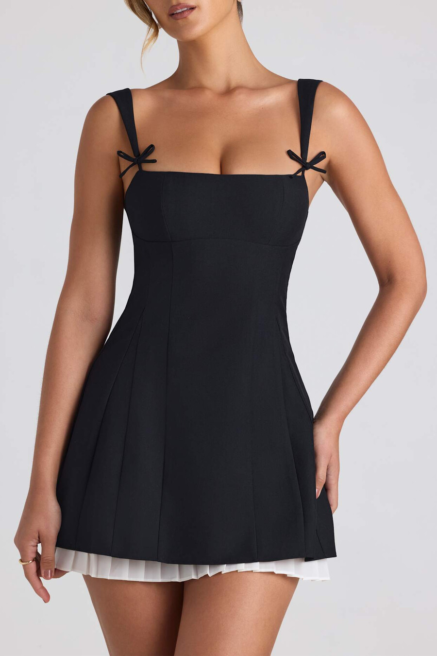 vestido curto evasê plissado com detalhe de laço na cor preta.