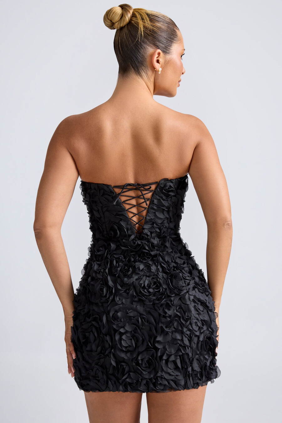 vestido curto evasê tomara que caia com apliques florais na cor preta.