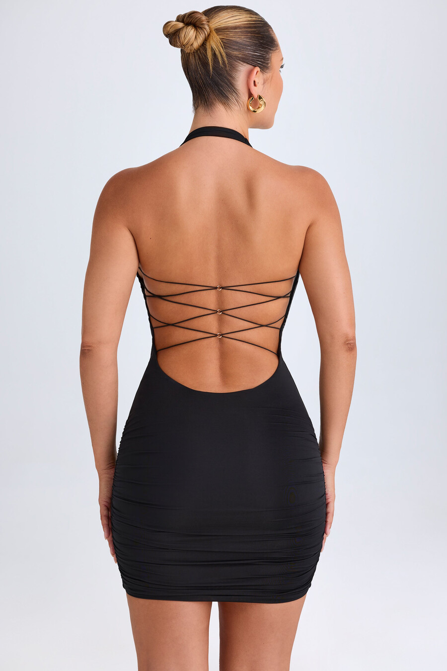 vestido curto com decote drapeado e detalhes em metal na cor preta.