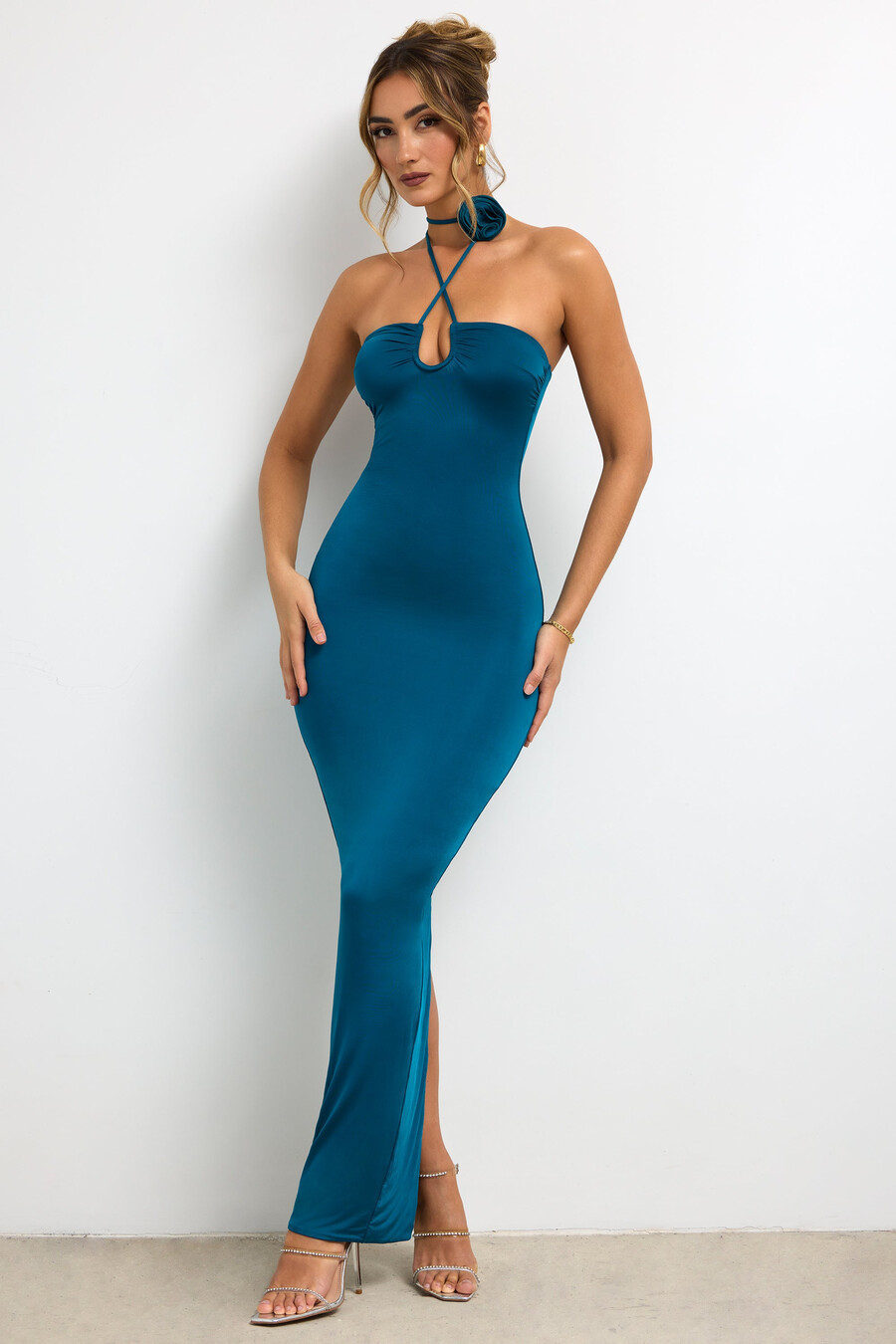 vestido longo justo de jérsei com detalhe de rosa e decote halter na cor verde-azulado escuro.