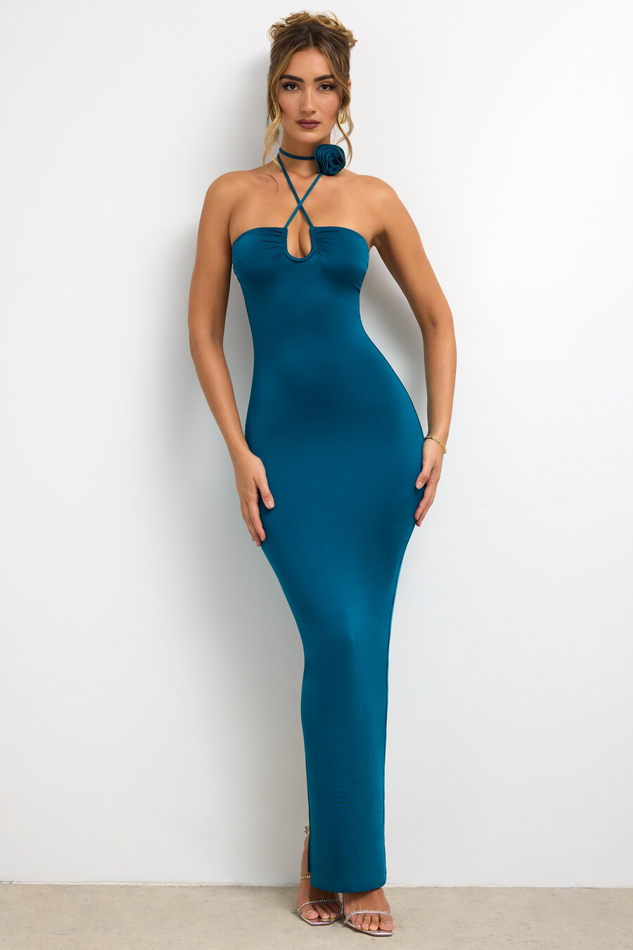 vestido longo justo de jérsei com detalhe de rosa e decote halter na cor verde-azulado escuro.