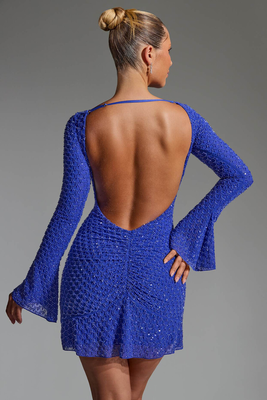 vestido curto evasê com costas abertas e detalhes bordados na cor azul cobalto.