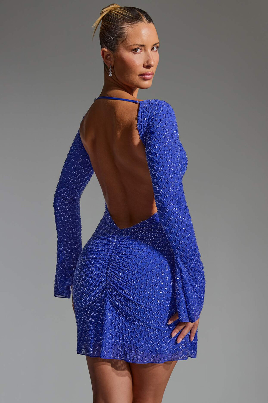 vestido curto evasê com costas abertas e detalhes bordados na cor azul cobalto.