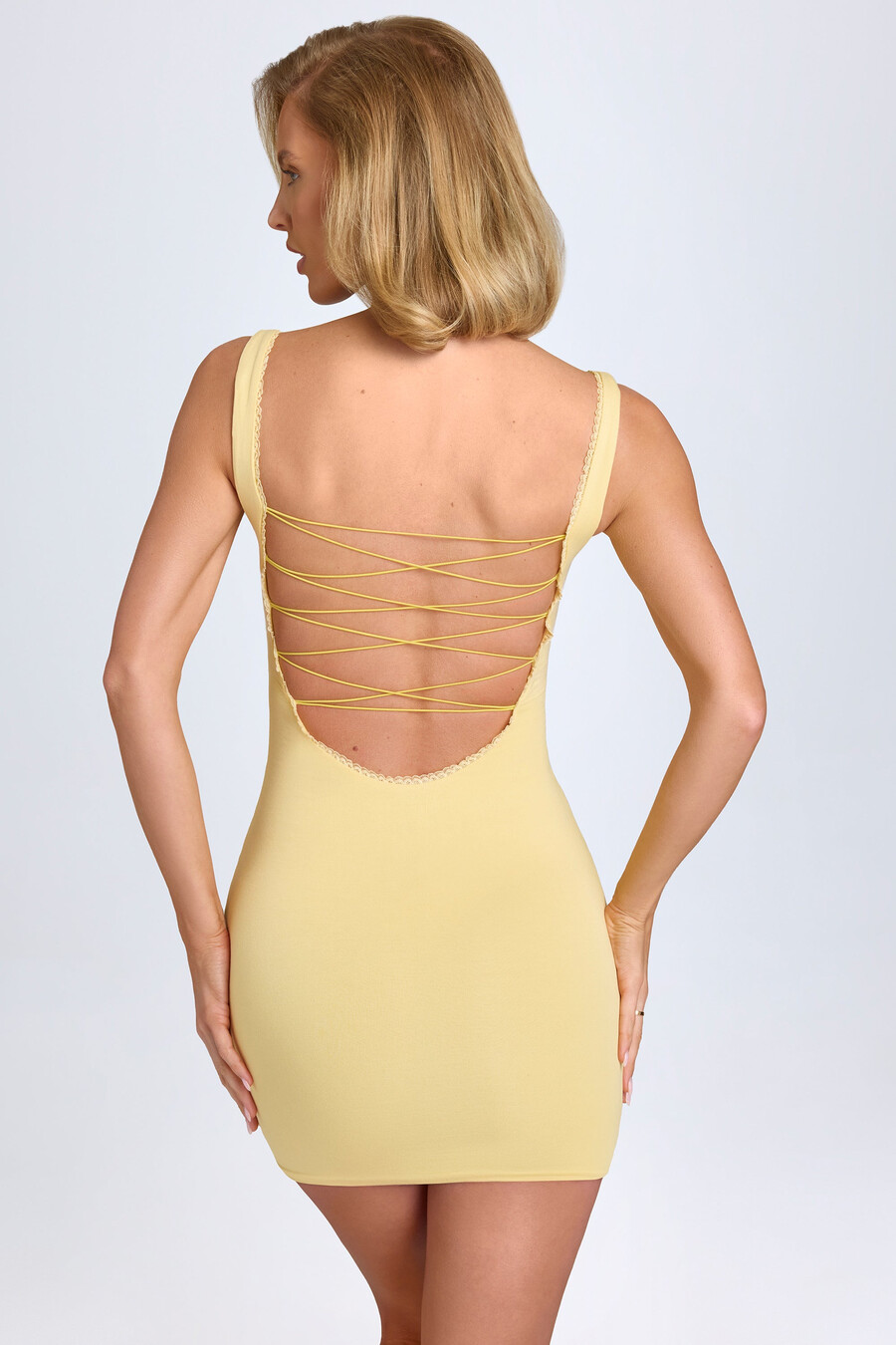 vestido curto justo ao corpo em modal com detalhes em renda na cor amarelo pastel.