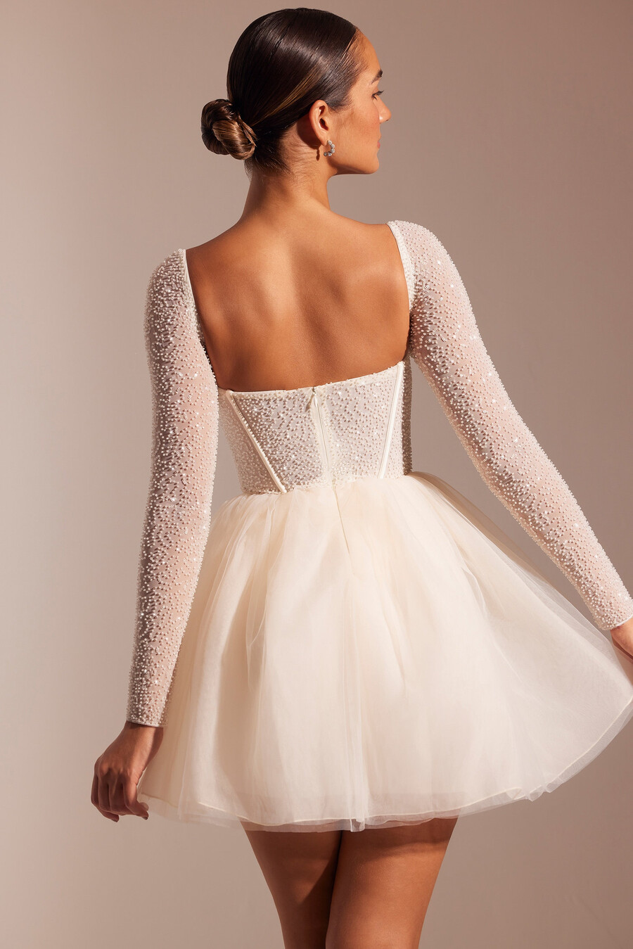 vestido curto de tule com mangas compridas e detalhes bordados na cor marfim.