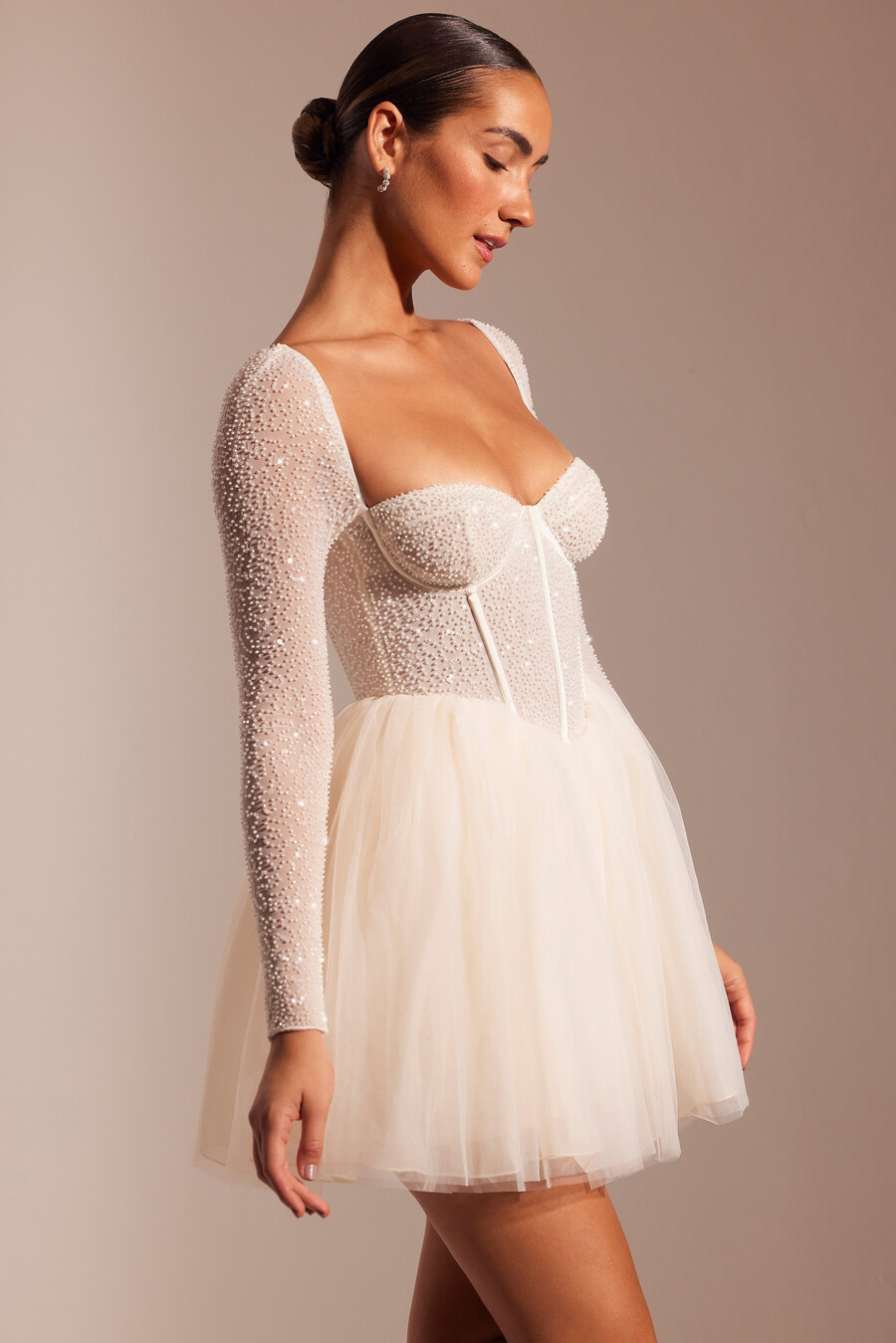 vestido curto de tule com mangas compridas e detalhes bordados na cor marfim.