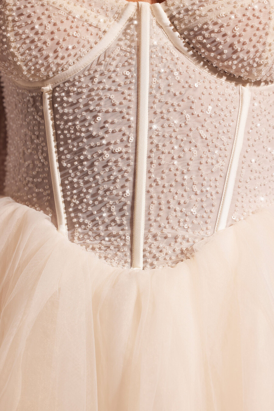 vestido curto de tule com mangas compridas e detalhes bordados na cor marfim.