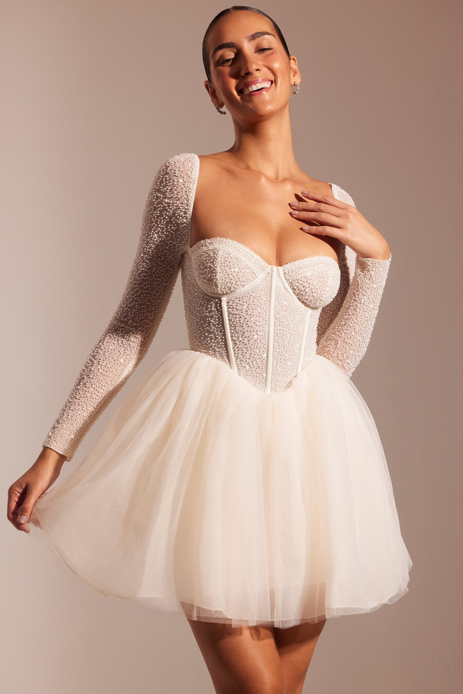 vestido curto de tule com mangas compridas e detalhes bordados na cor marfim.