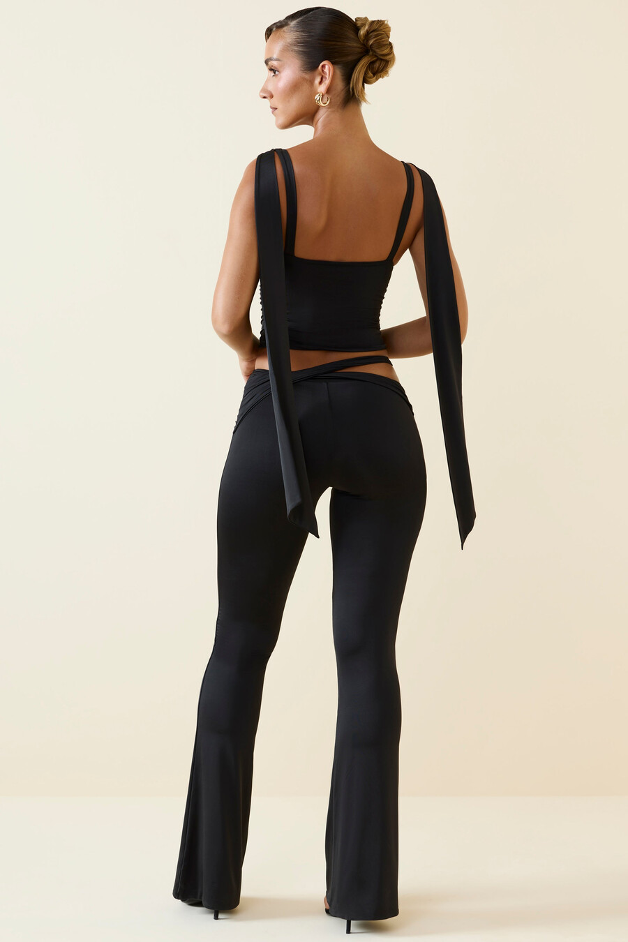 calça flare de cintura média com recortes na cor preta.