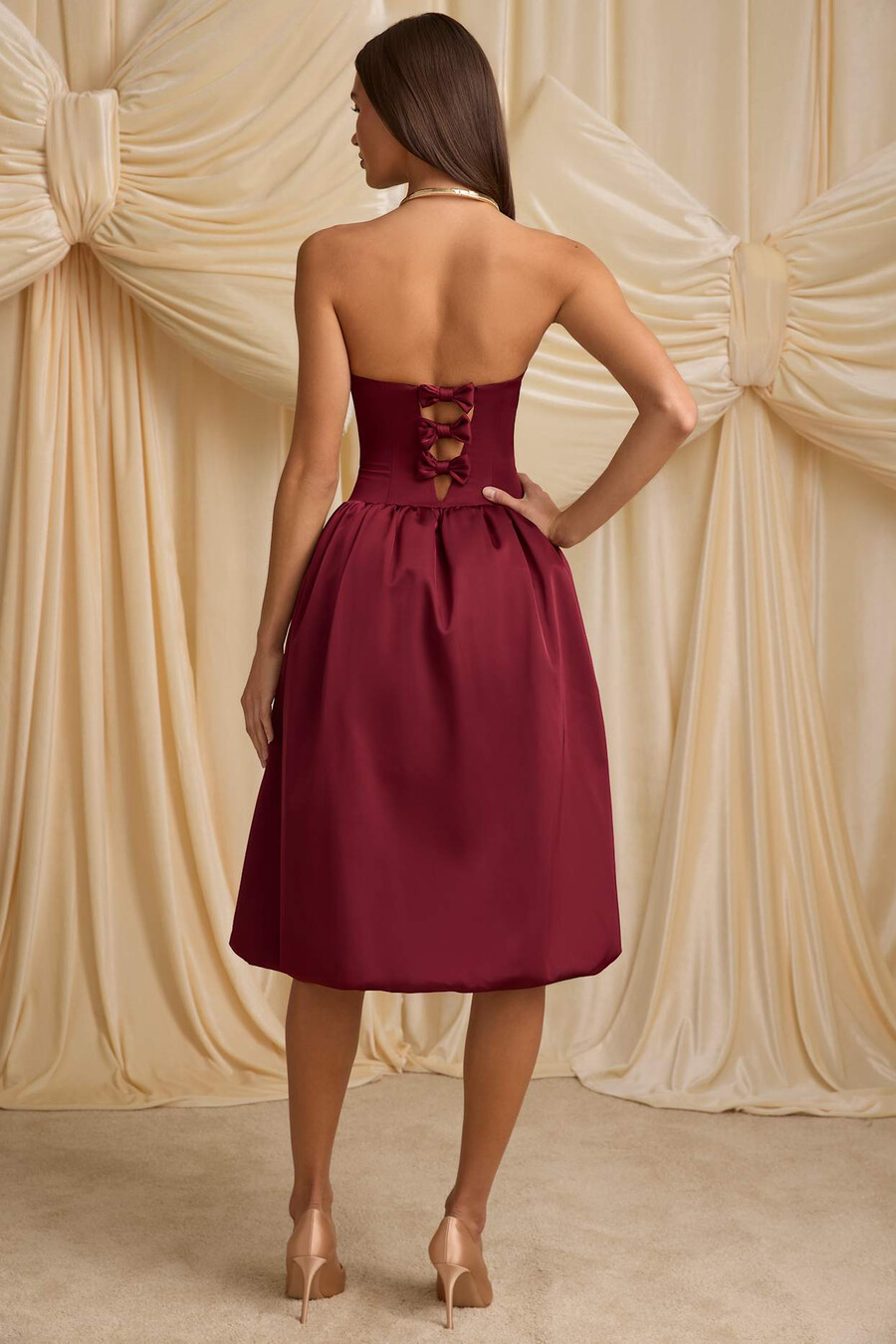 vestido midi conversível com detalhe de laço e barra balonê na cor vermelho vinho.