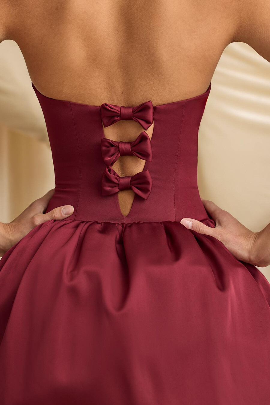 vestido midi conversível com detalhe de laço e barra balonê na cor vermelho vinho.
