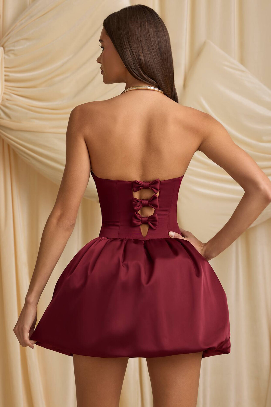 vestido midi conversível com detalhe de laço e barra balonê na cor vermelho vinho.