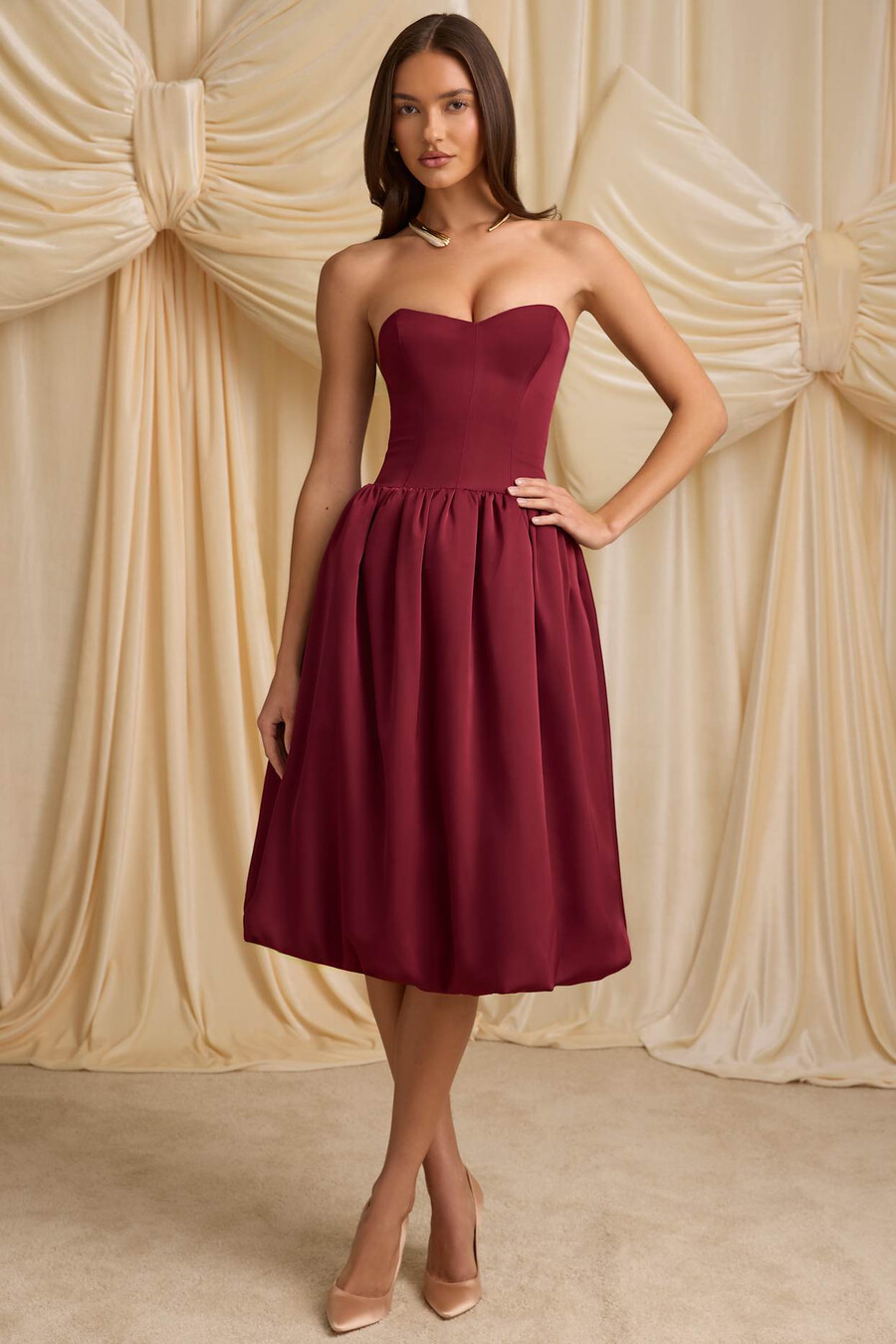 vestido midi conversível com detalhe de laço e barra balonê na cor vermelho vinho.