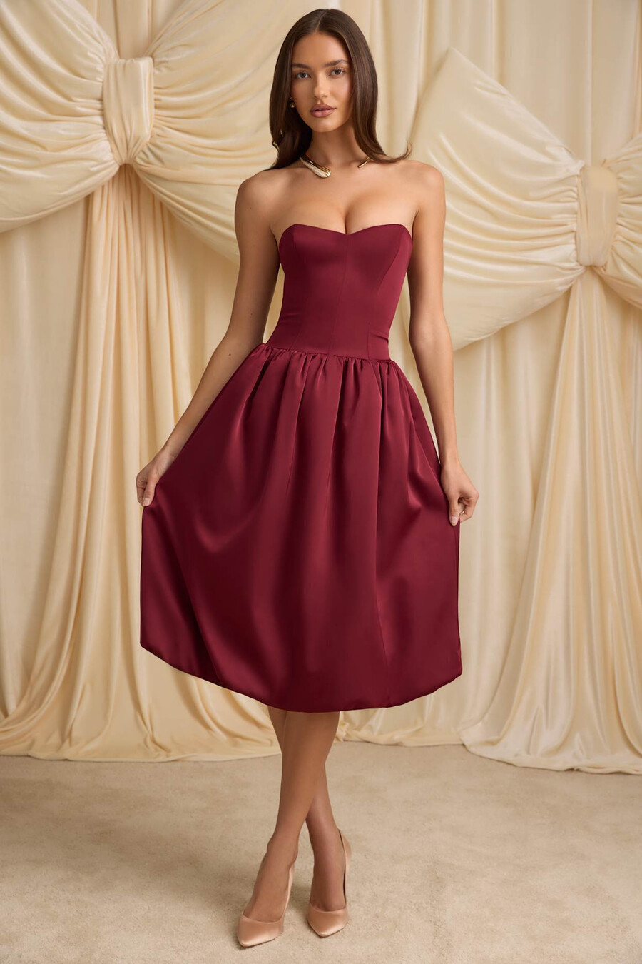 vestido midi conversível com detalhe de laço e barra balonê na cor vermelho vinho.