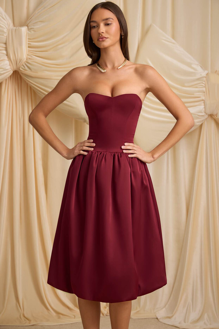 vestido midi conversível com detalhe de laço e barra balonê na cor vermelho vinho.