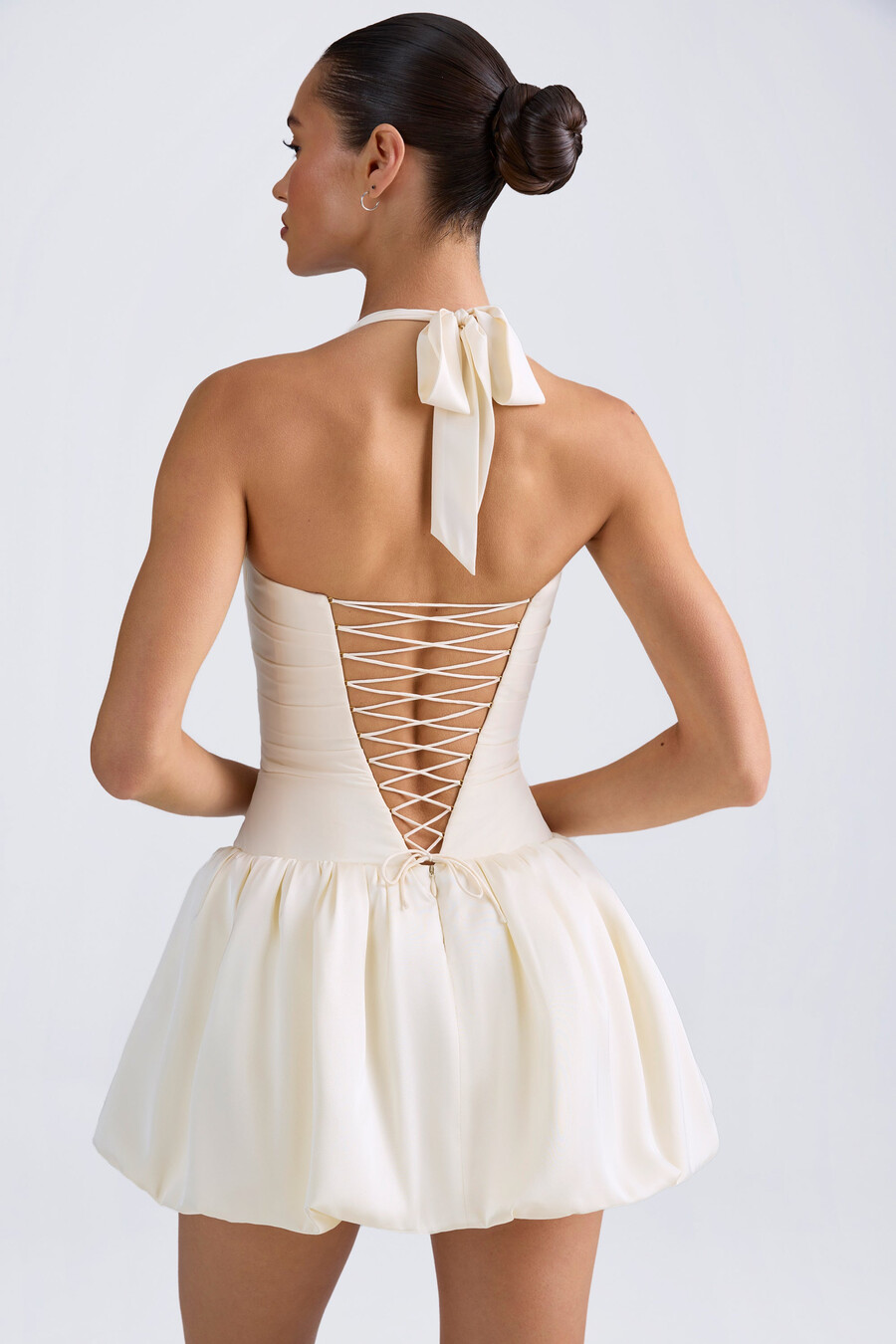 vestido micro mini com corpete amarração nas costas e barra balonê na cor marfim.