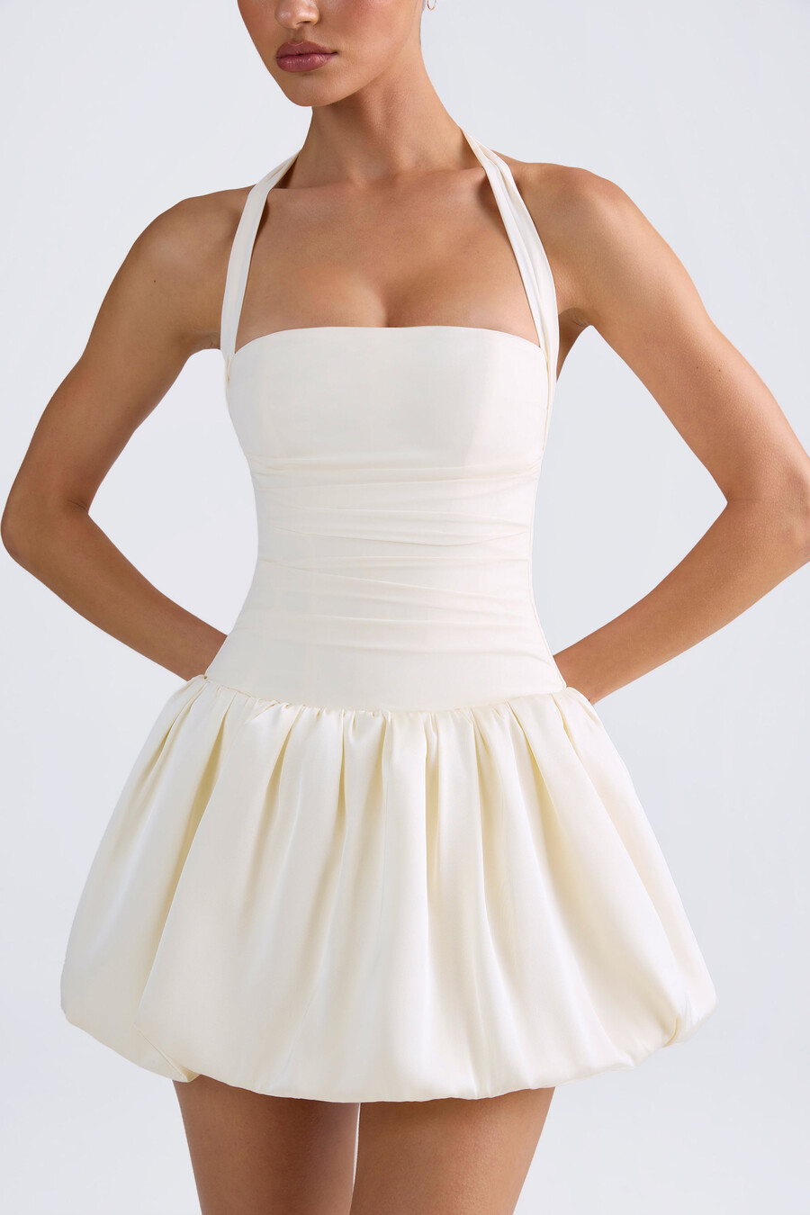 vestido micro mini com corpete amarração nas costas e barra balonê na cor marfim.