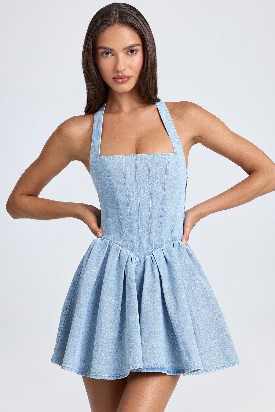 vestido micro mini com corpete e decote halter em lavagem stonewash azul claro.