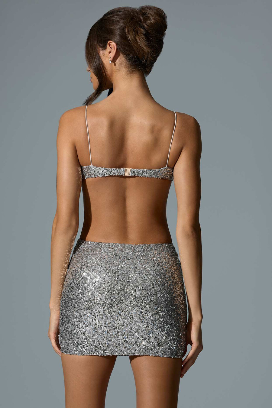vestido curto prateado com recortes e aplicações.