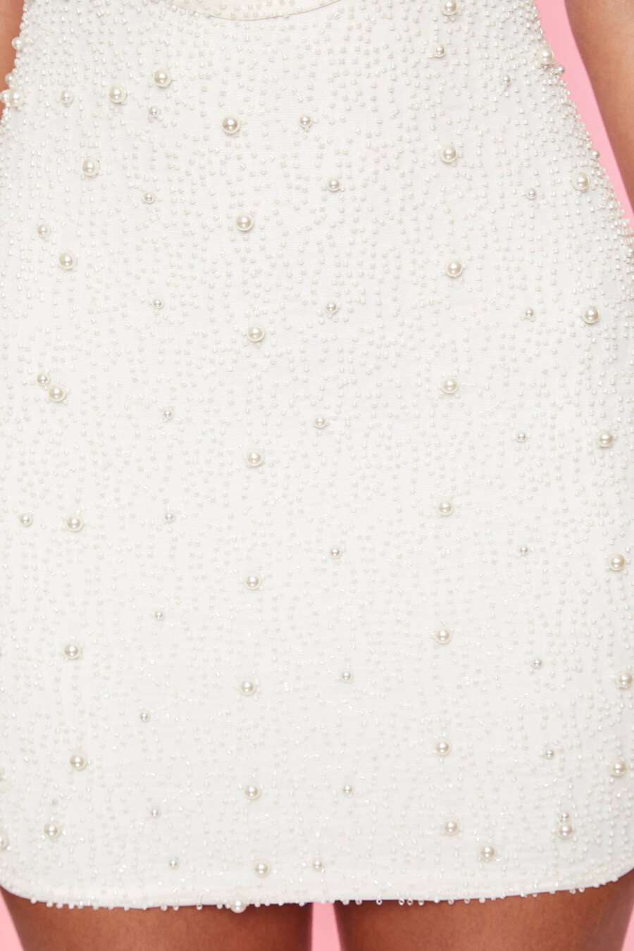 vestido curto branco com decote profundo e detalhes bordados.