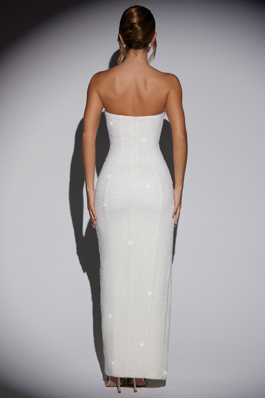 vestido longo bandeau com decote drapeado e aplicações na cor marfim.