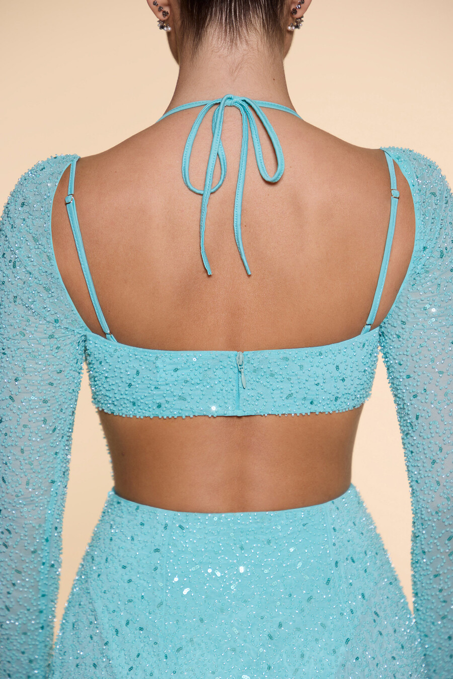 vestido longo com gola drapeada e aplicações na cor azul-turquesa.