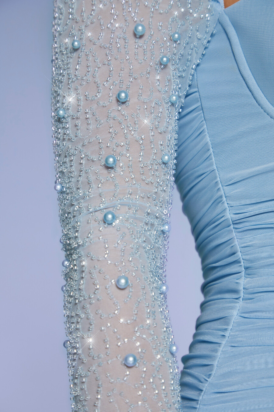vestido curto azul com mangas compridas e detalhes bordados.