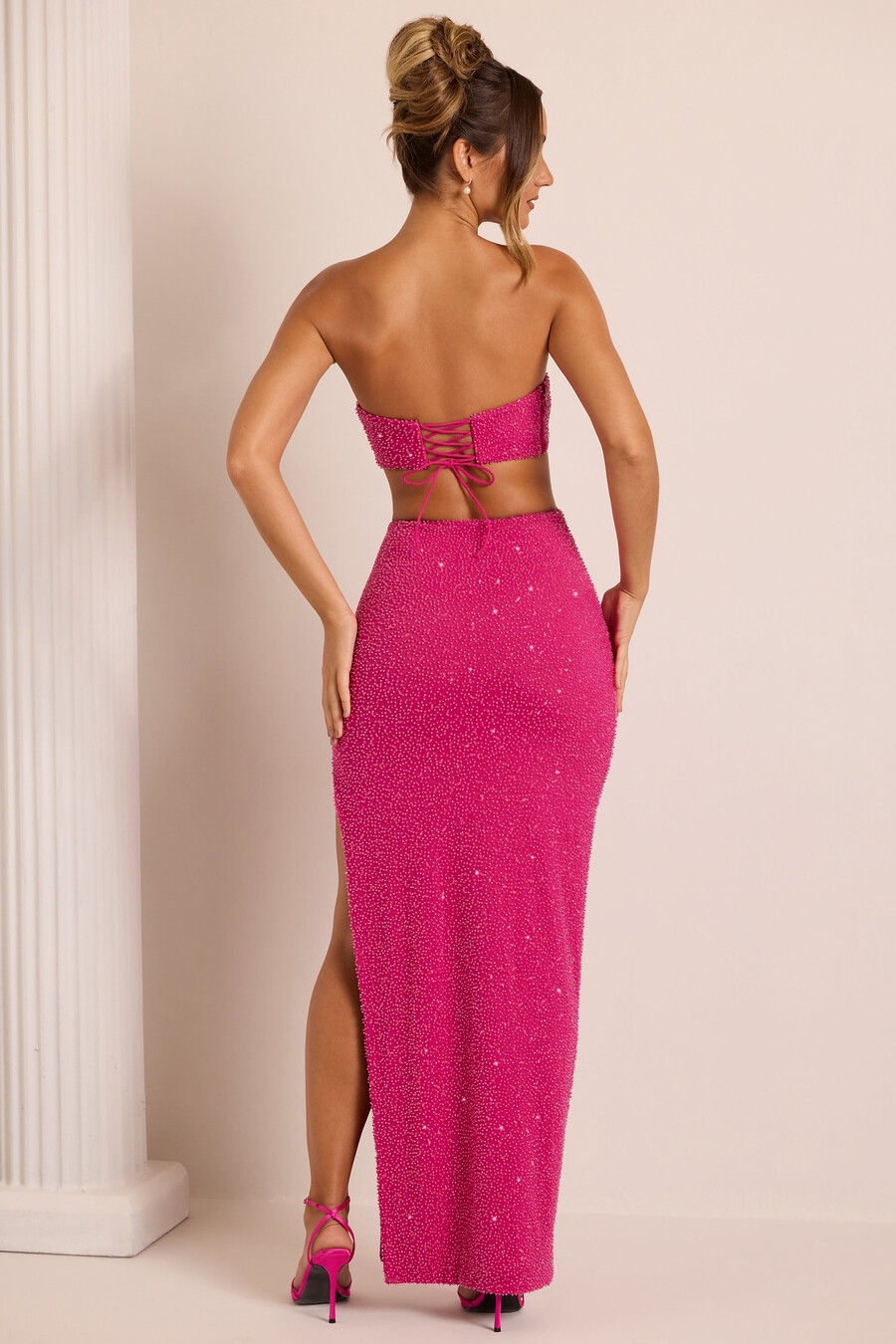 vestido longo com recortes e aplicações na cor fúcsia.