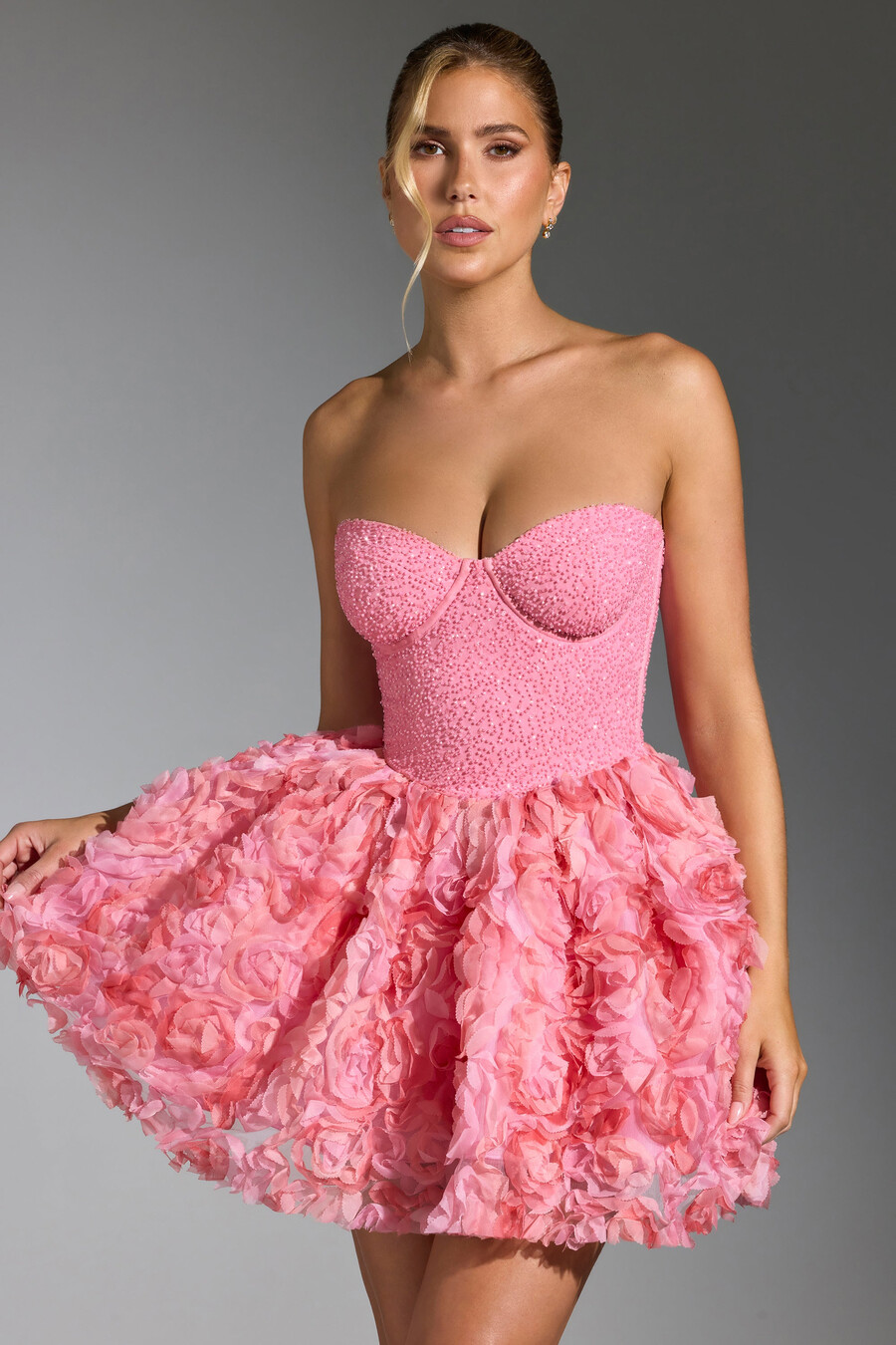 vestido curto rosa com aplicações florais e amarração nas costas.