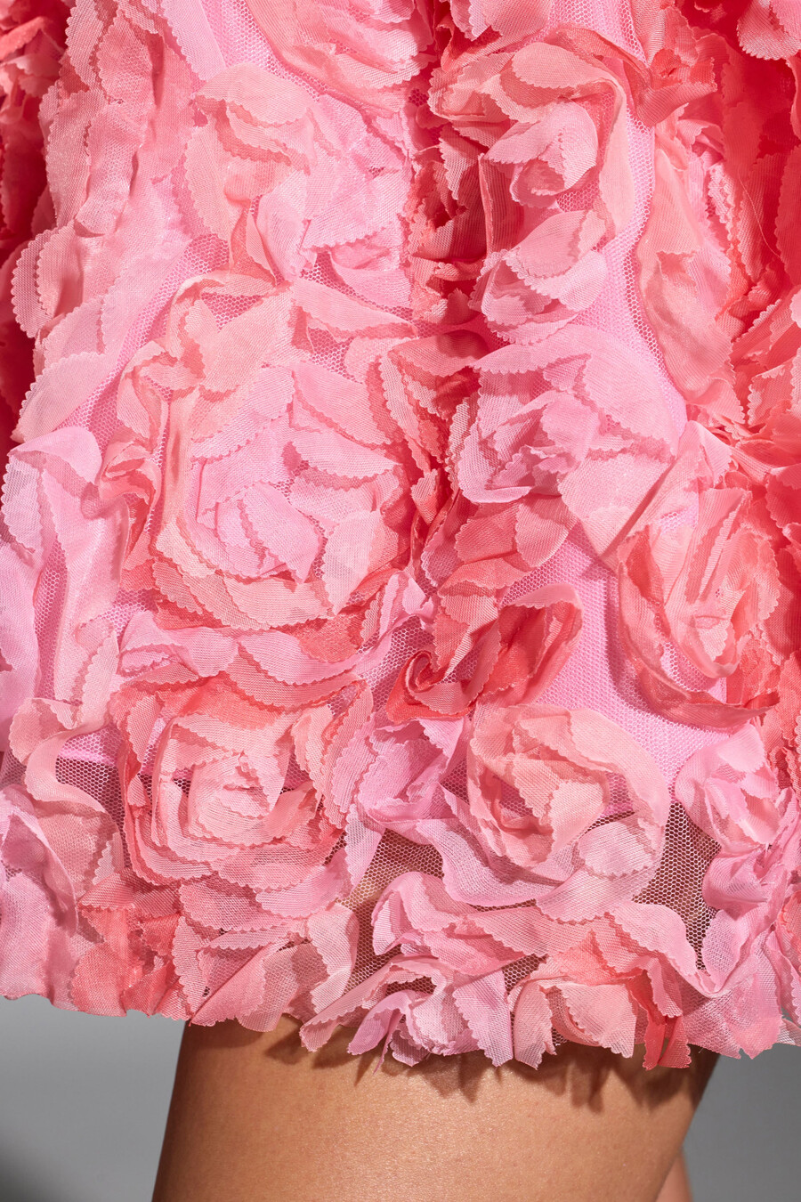vestido curto rosa com aplicações florais e amarração nas costas.