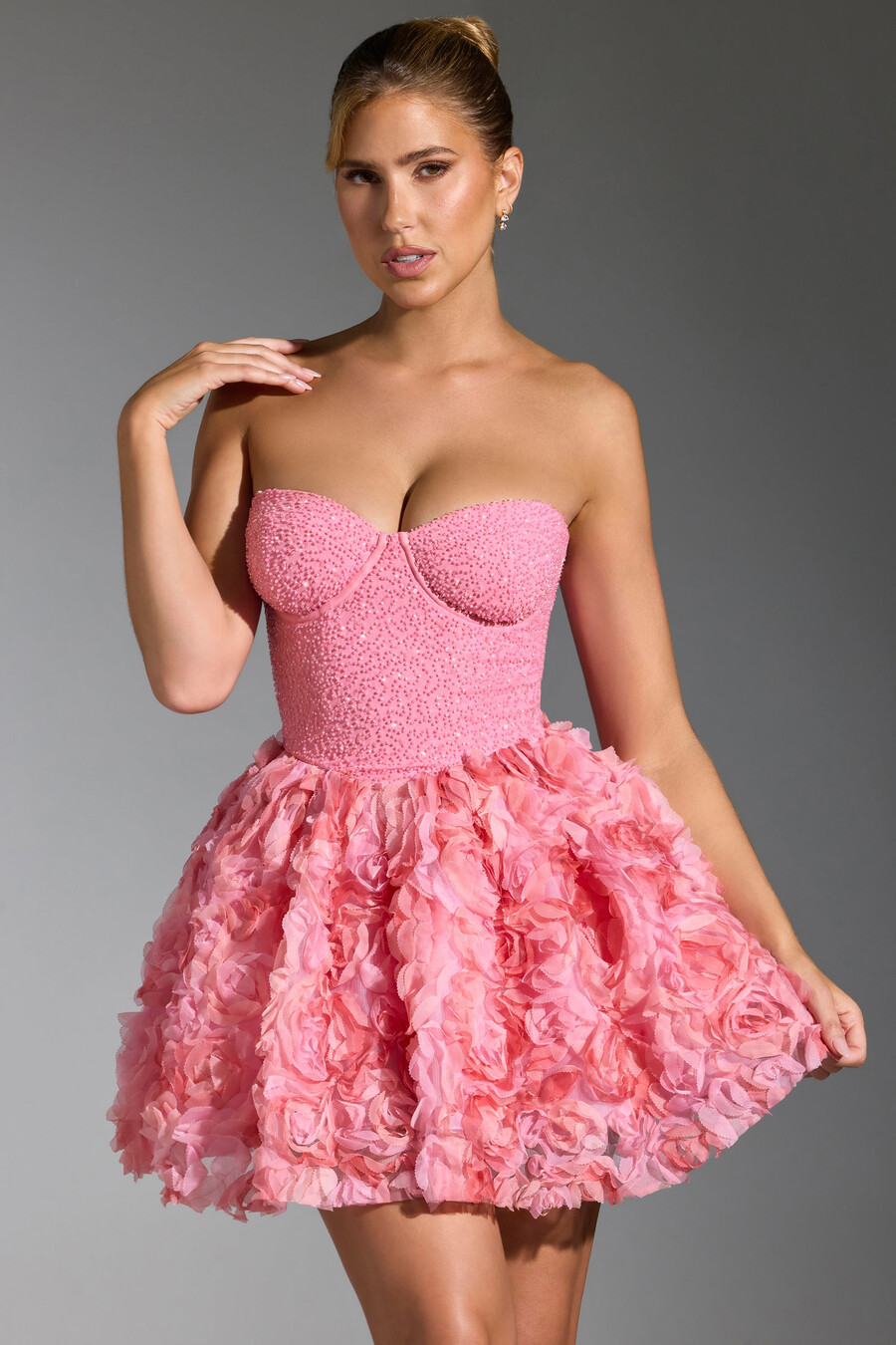vestido curto rosa com aplicações florais e amarração nas costas.