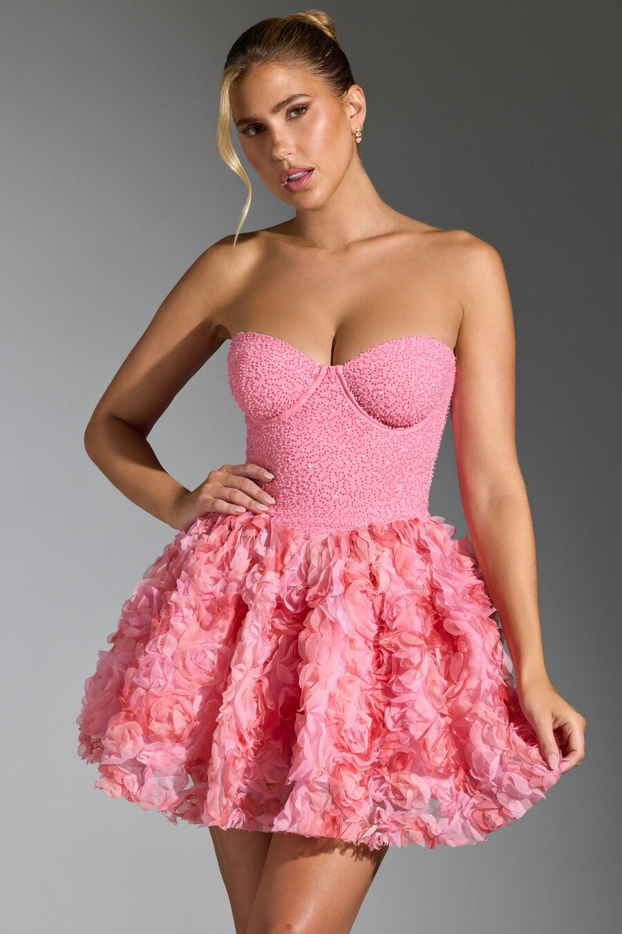 vestido curto rosa com aplicações florais e amarração nas costas.