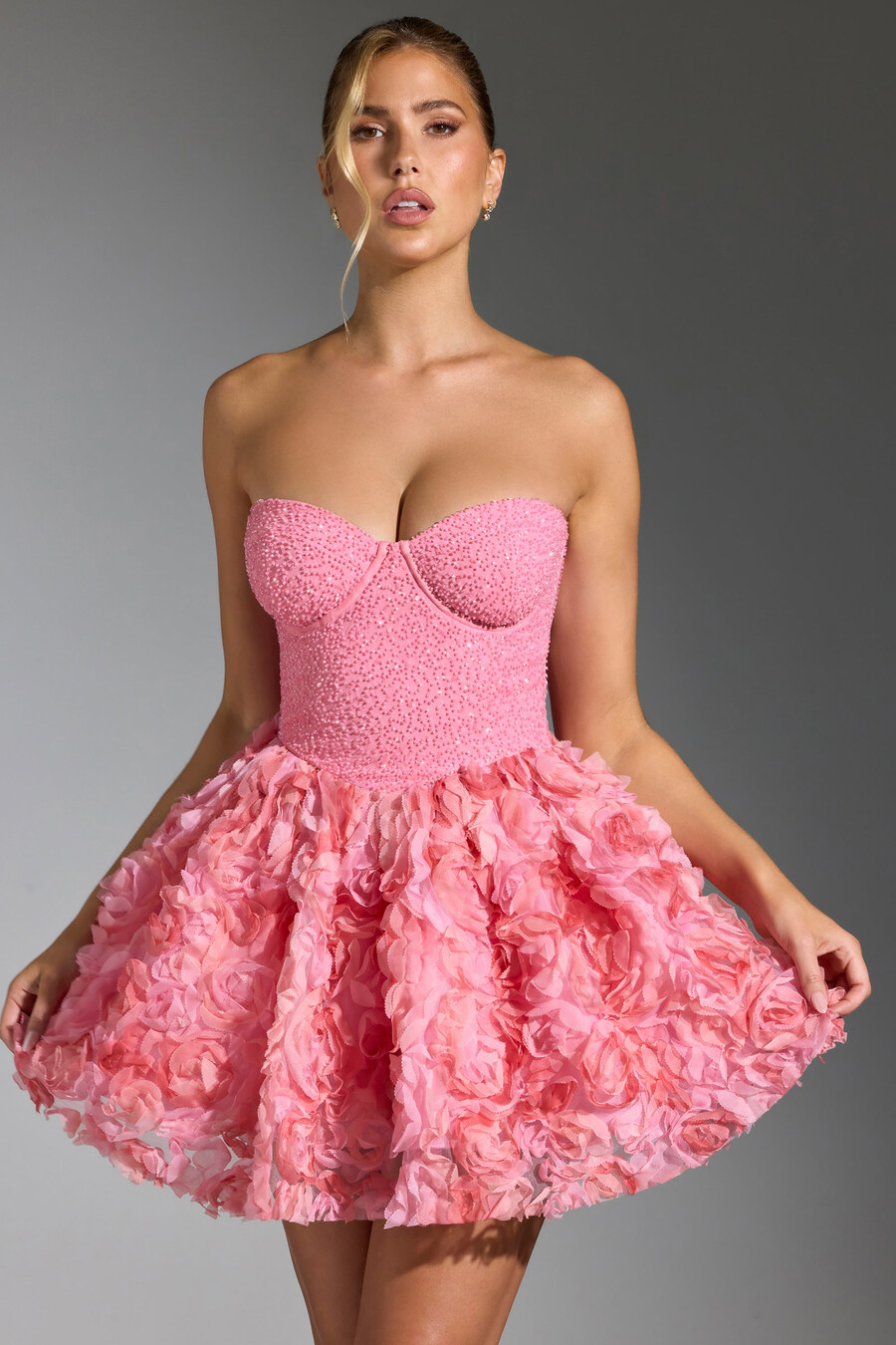vestido curto rosa com aplicações florais e amarração nas costas.