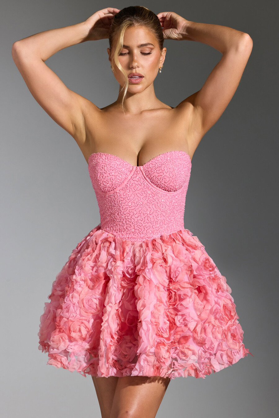 vestido curto rosa com aplicações florais e amarração nas costas.