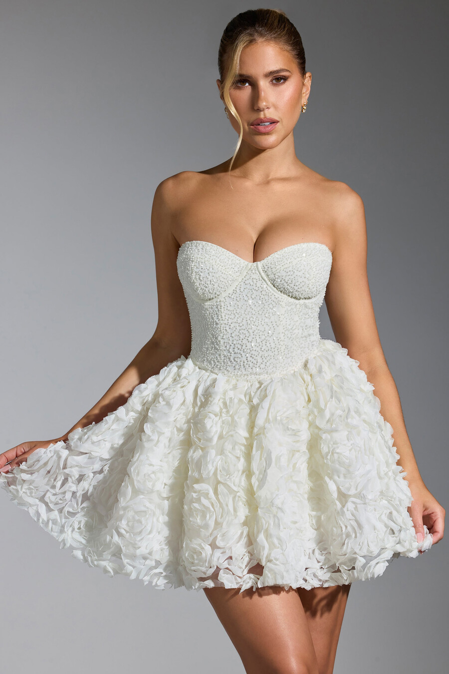 vestido curto com amarração e apliques florais na cor branca.