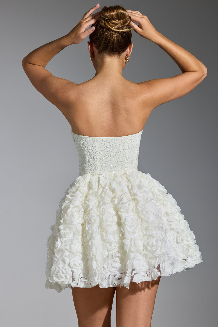 vestido curto com amarração e apliques florais na cor branca.