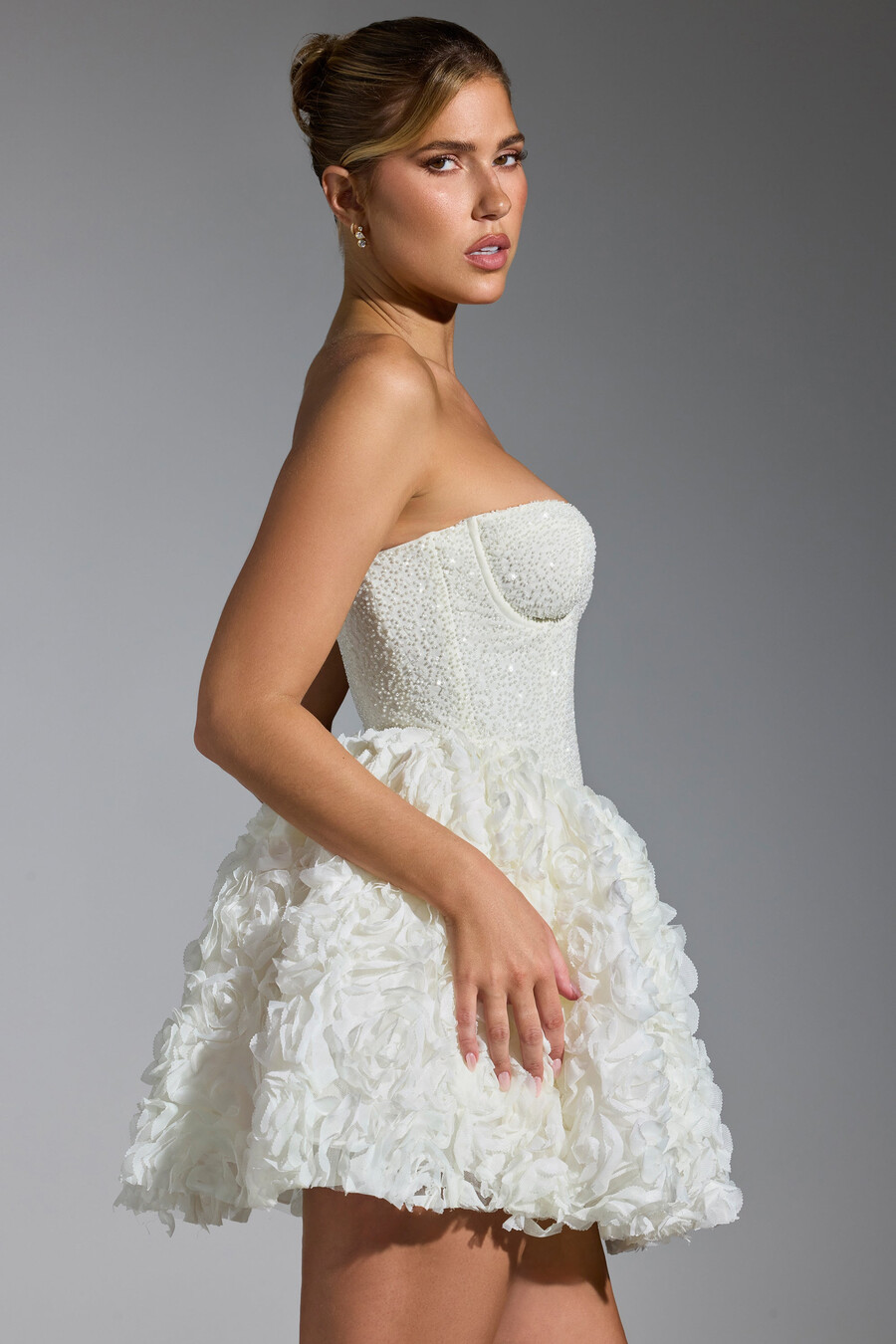 vestido curto com amarração e apliques florais na cor branca.