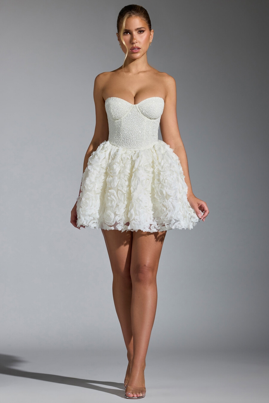 vestido curto com amarração e apliques florais na cor branca.