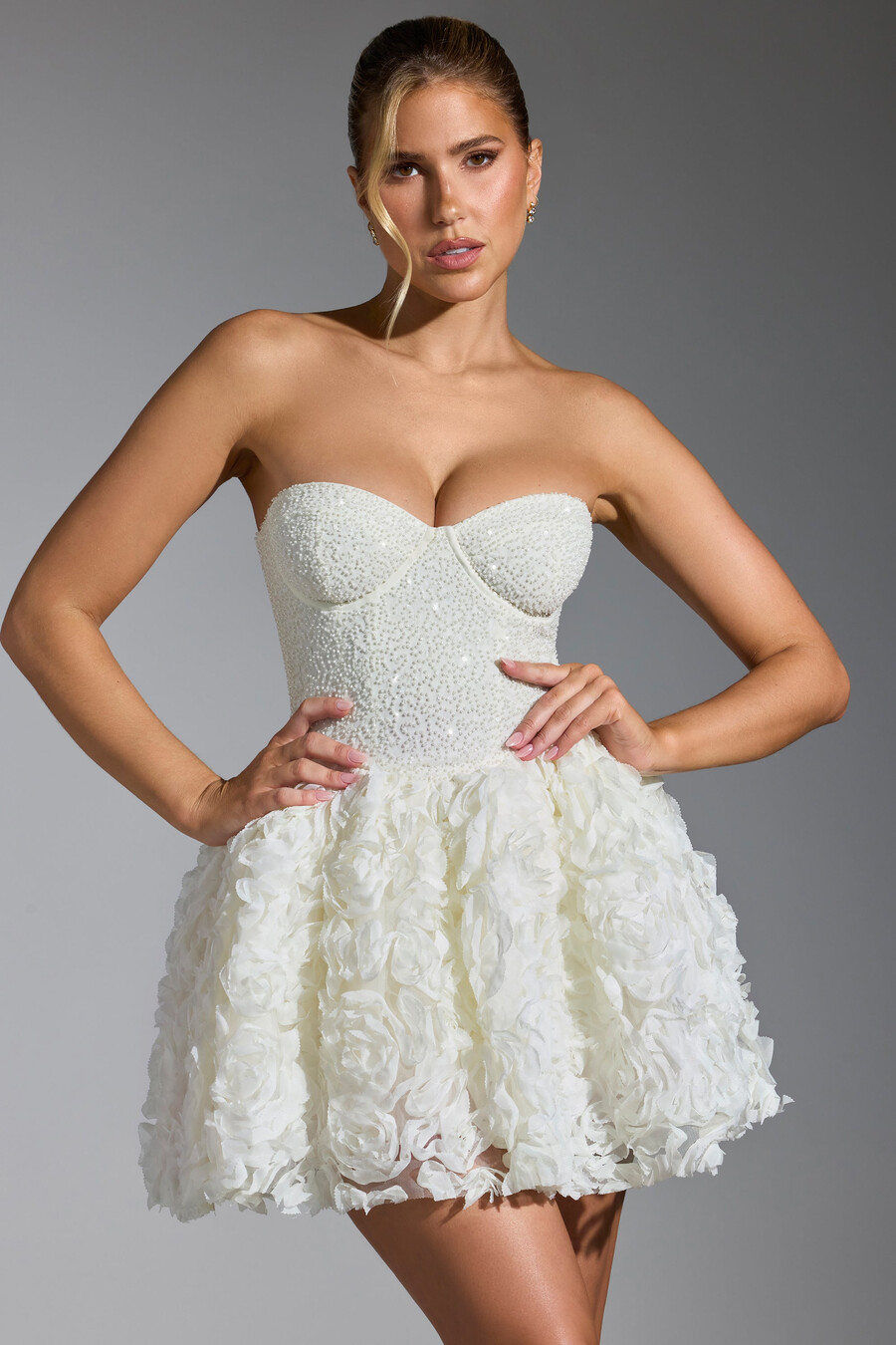vestido curto com amarração e apliques florais na cor branca.