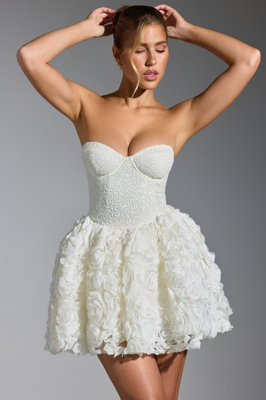 vestido curto com amarração e apliques florais na cor branca.