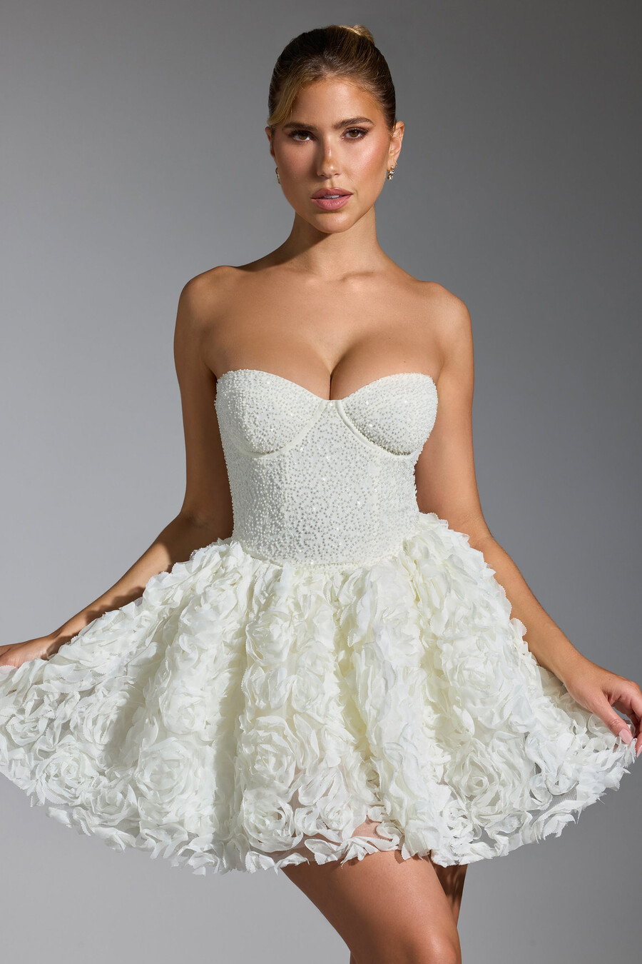 vestido curto com amarração e apliques florais na cor branca.