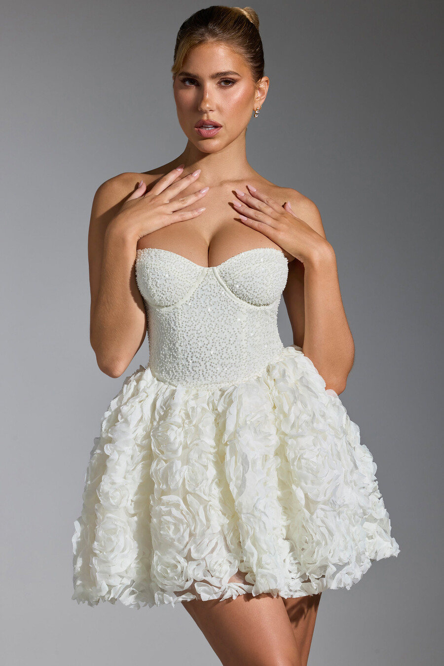 vestido curto com amarração e apliques florais na cor branca.