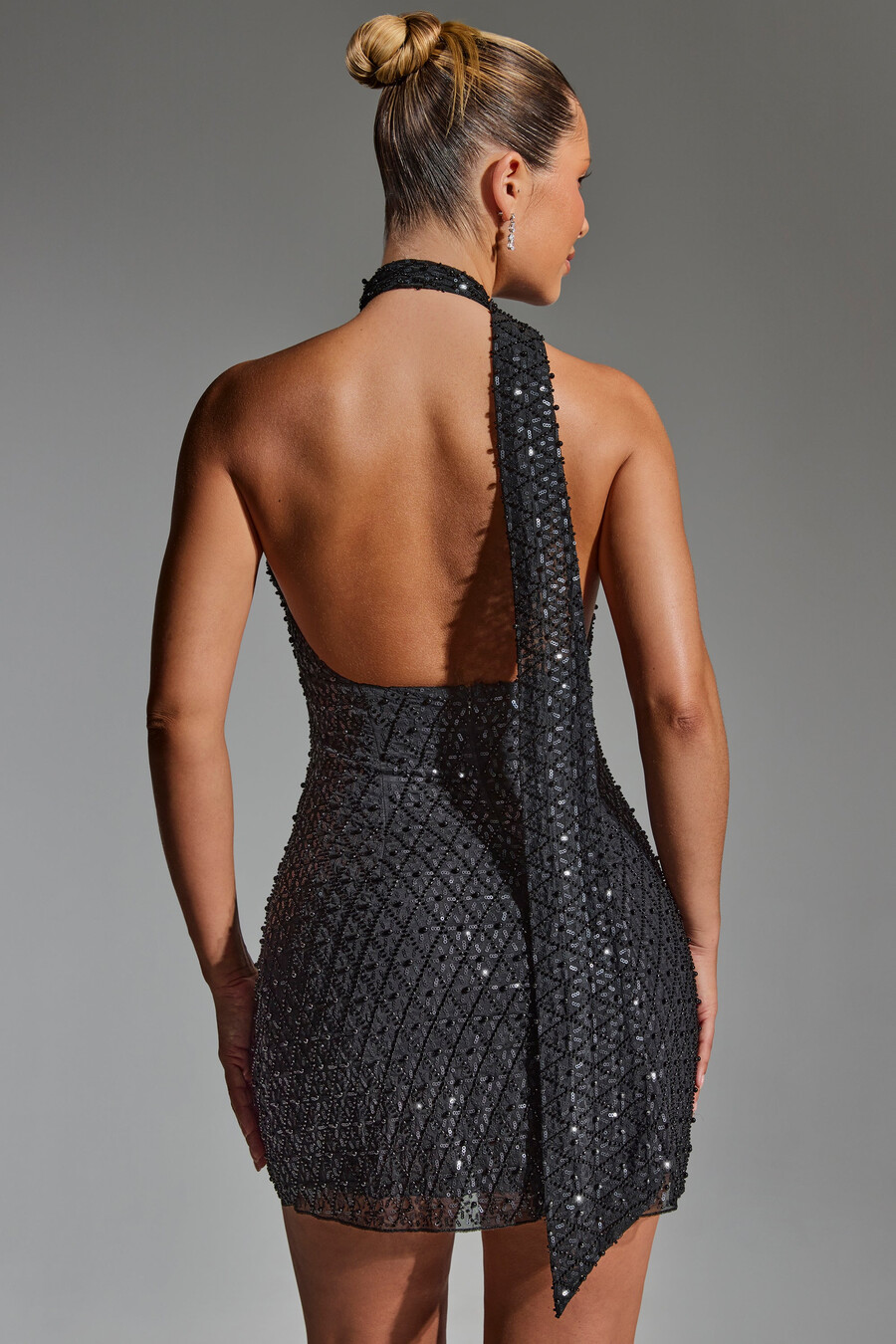 vestido curto preto com decote halter e detalhe de lenço bordado.