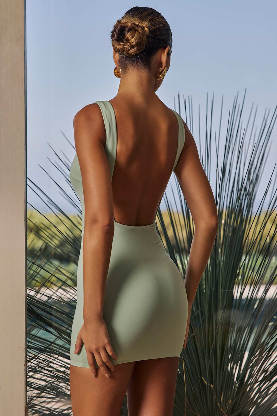 vestido curto drapeado com costas abertas na cor verde.