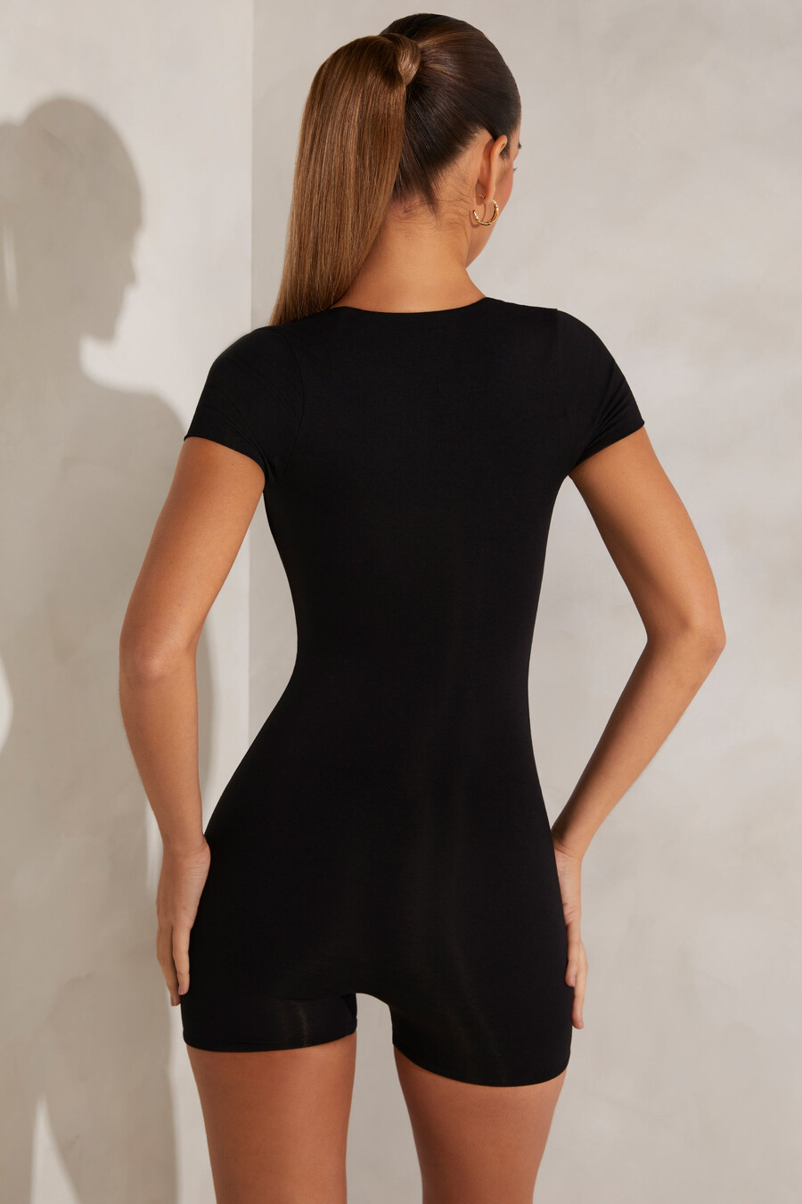 collant preto com mangas curtas e decote quadrado.