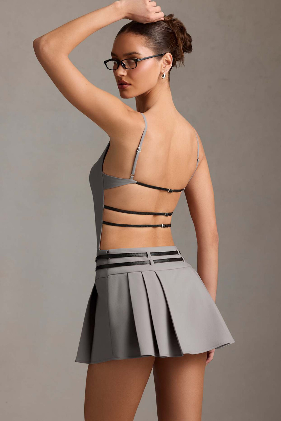 vestido curto plissado com cinto e costas abertas na cor cinza.